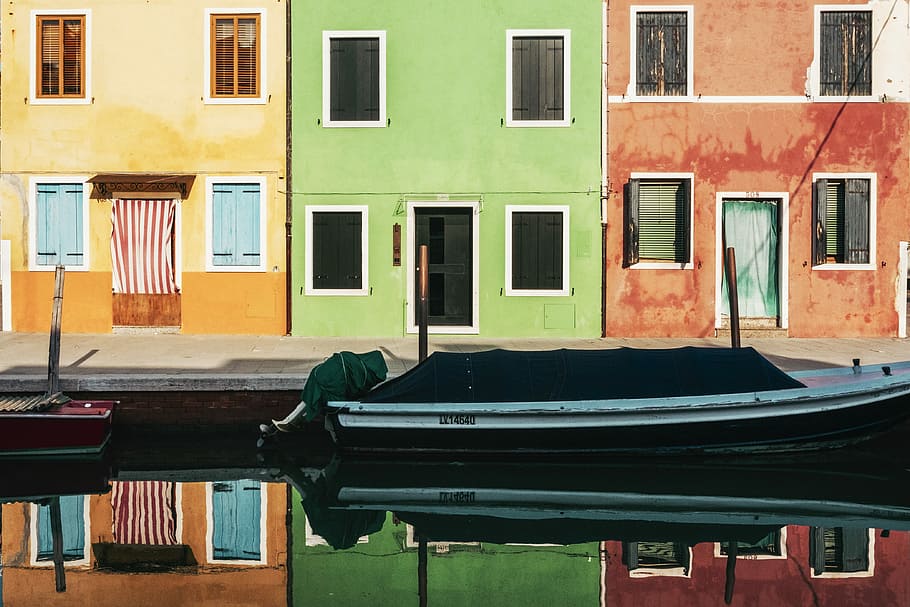 open building window, white outboard boat on body of water in front of houses HD wallpaper