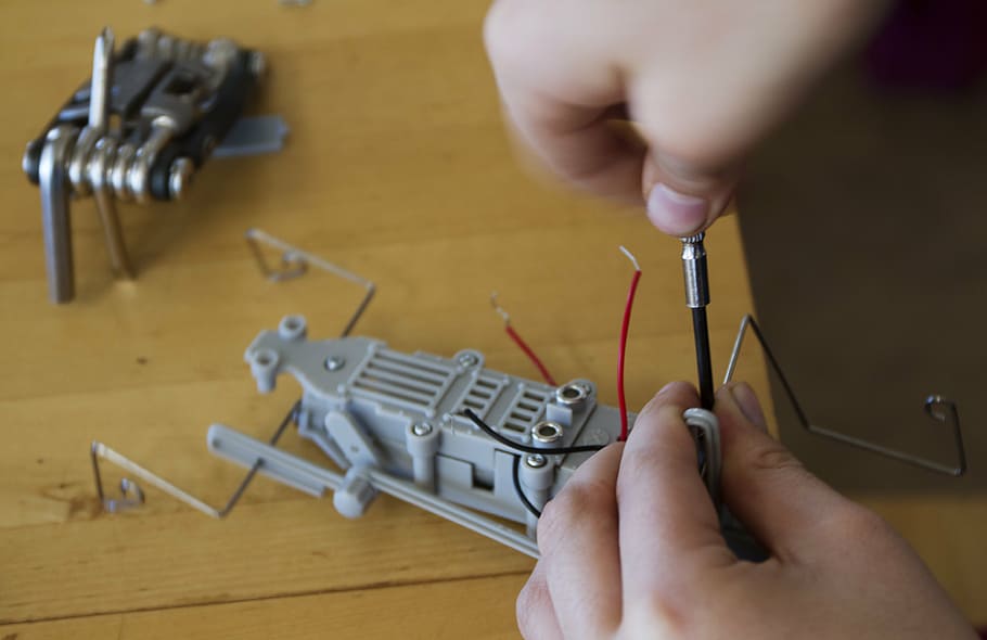 person repairing gray toy, assemble, robot, tools, building HD wallpaper