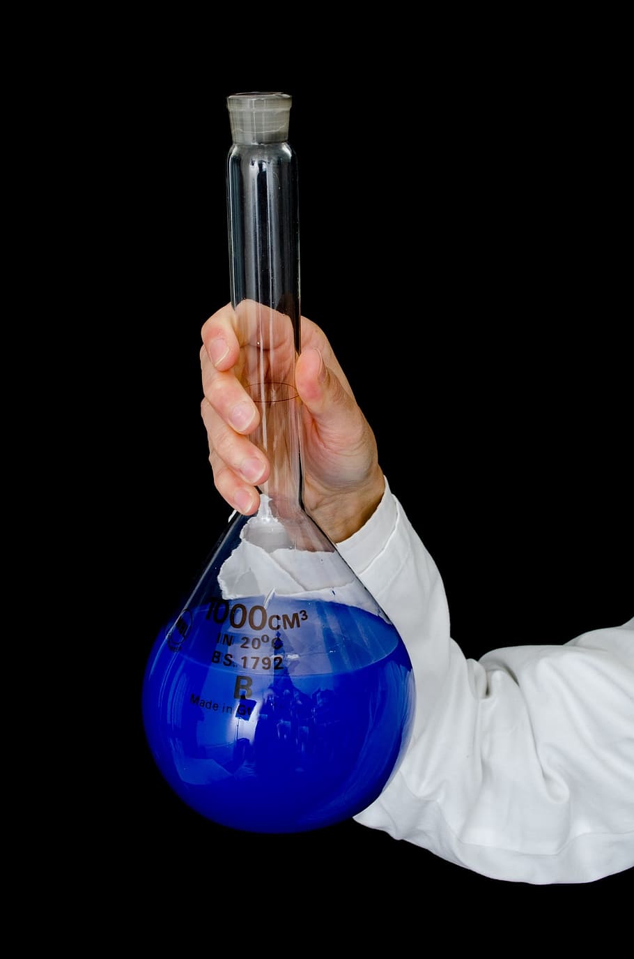 person holding filled clear glass tube, laboratory, liquid, blue