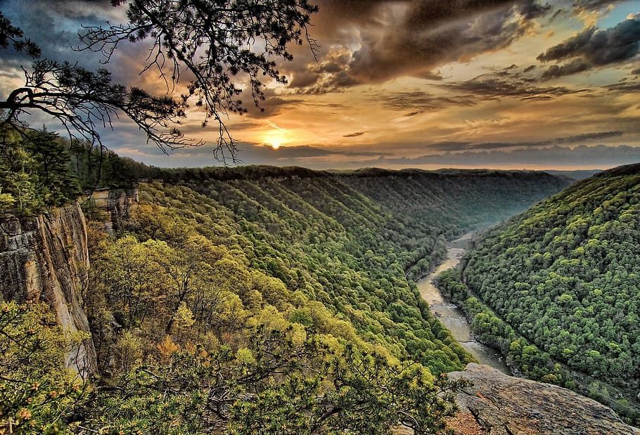 green valley near lake under cloudy sky, new river gorge, scenic