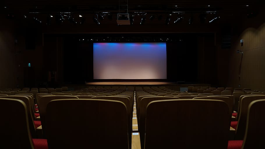 closeup photo of screen near chairs, theatre, seats, movie Theater
