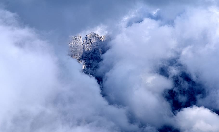 rock formation covered with clouds, white cloudy sky, stormy HD wallpaper