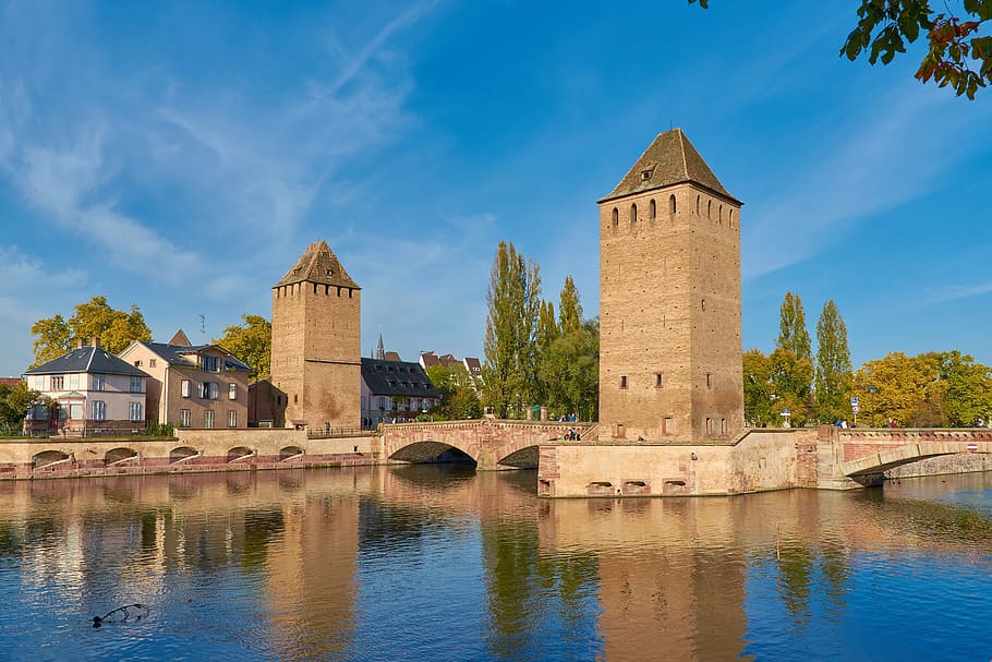 two brown brick buildings near body of water, alsace, strasbourg
