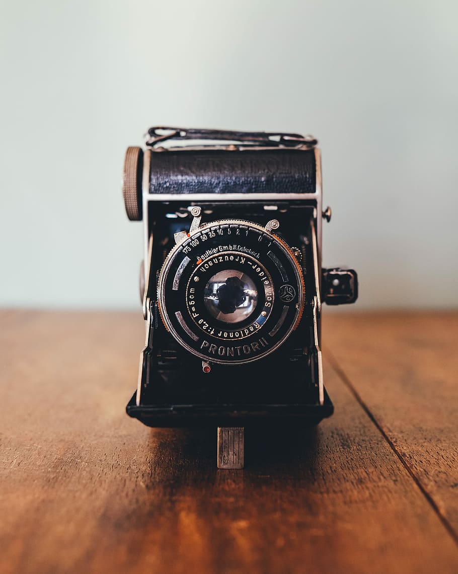 black Prontor II camera on brown wooden board, shallow focus of vintage black camera HD wallpaper