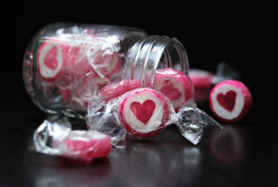 person taking photo of white-and-pink candies with jar, candy HD wallpaper