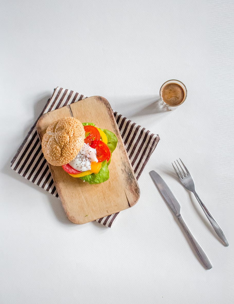 sandwich on brown wooden chopping board beside fork and bread knife HD wallpaper