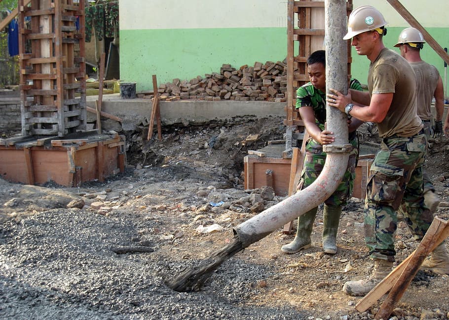 two man holding white tube in front of cement, working, workers HD wallpaper