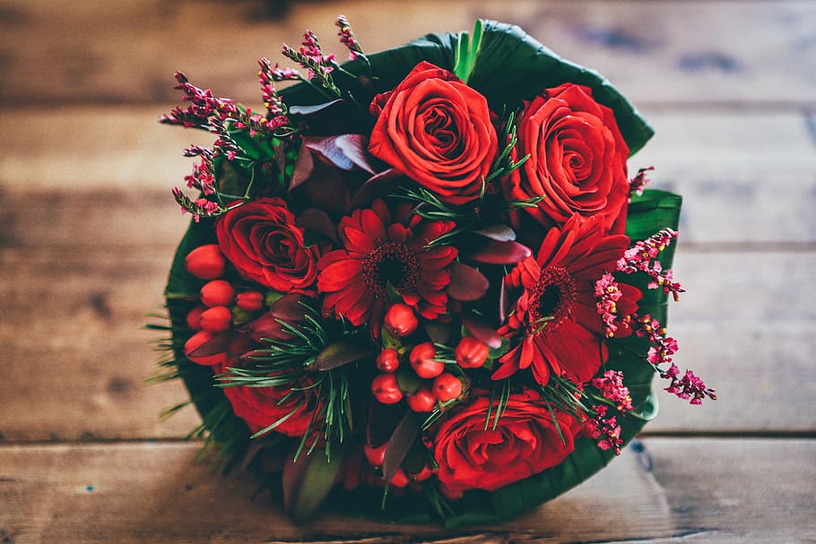 red flower bouquet on brown surface, shallow focus photography of bouquet of red rose HD wallpaper
