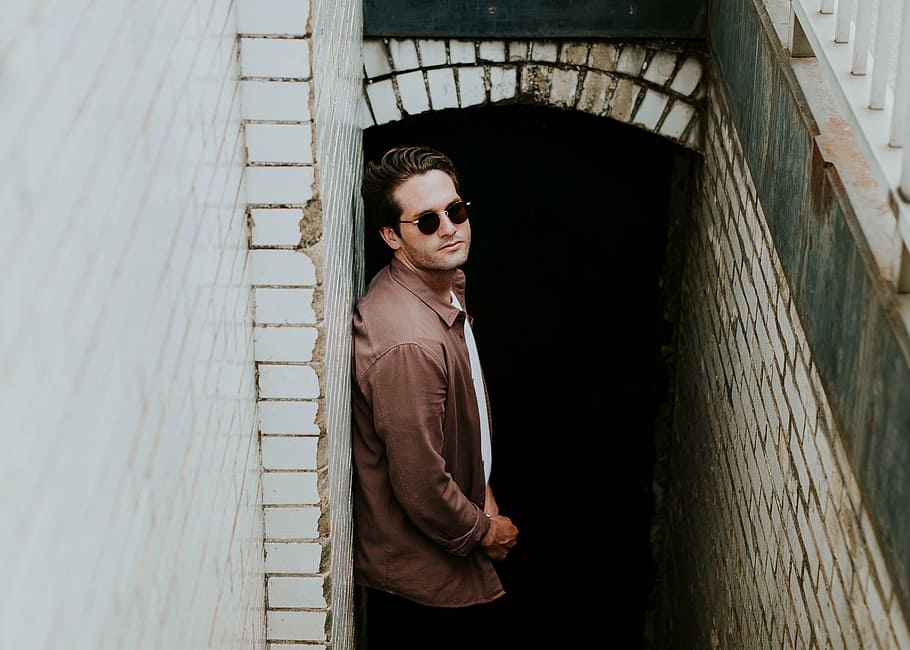man leaning on grey concrete wall looking up, people, guy, sunglasses HD wallpaper