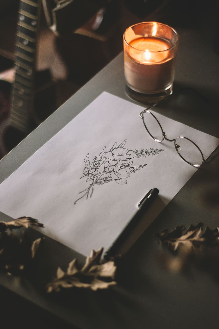 orange votive candle, flower sketch beside eyeglasses and candle HD wallpaper