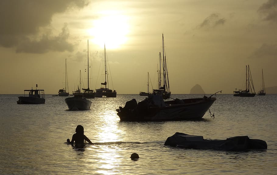silhouette of woman swimming on sea, sun, sunset, boot, sail