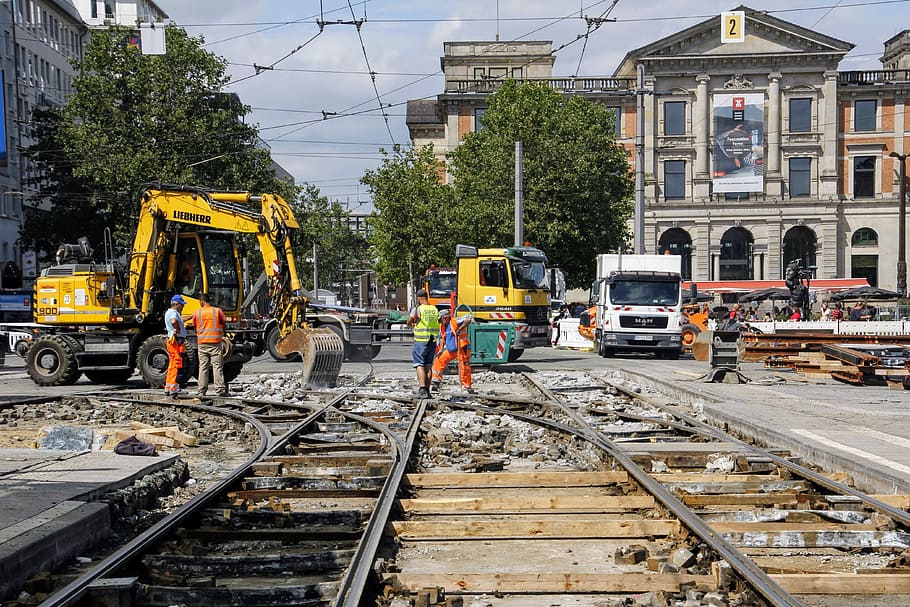 people working at the road and railroad near buildings, site HD wallpaper