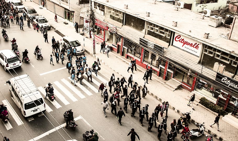 aerial view of parade in street, aerial shot of people walking on road beside buildings HD wallpaper