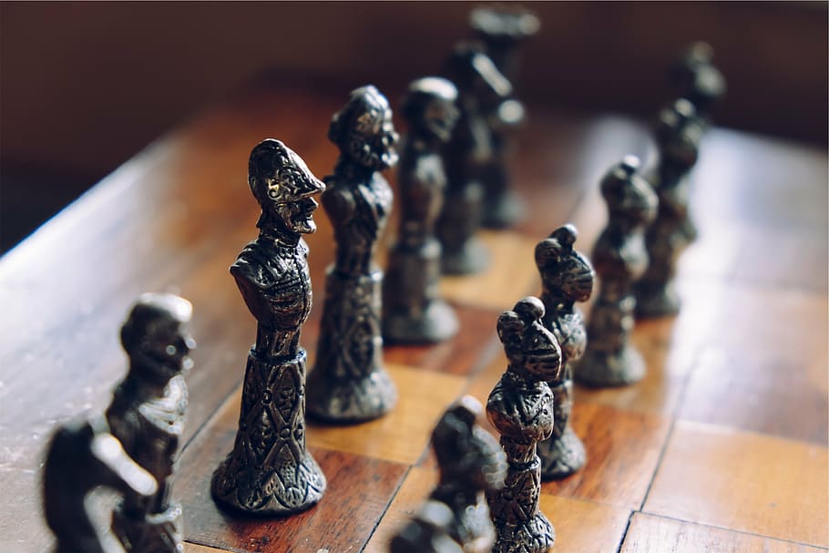 selective focus on gray chess piece lot on brown wooden checkered board HD wallpaper