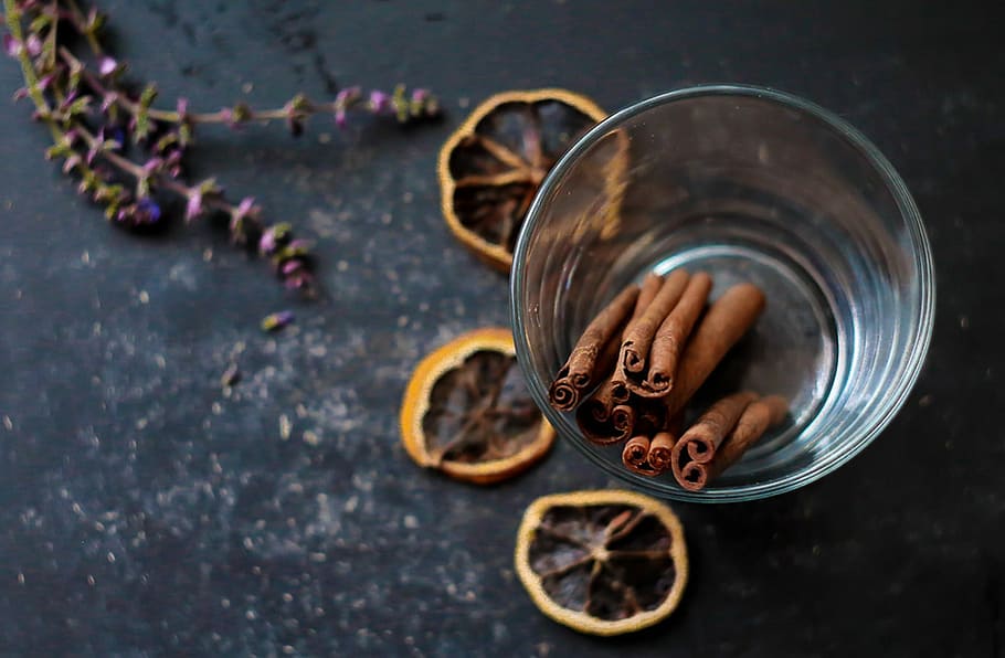 focus photo of brown cinnamon sticks in clear drinking glass cup HD wallpaper