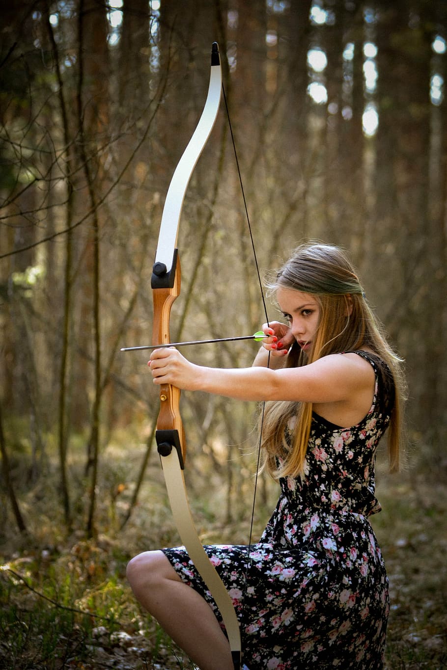 woman in black floral dress holding bow and arrow kneeling in forest, HD wallpaper
