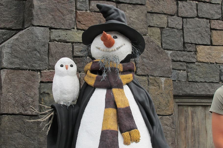 Harry Potter themed snowman with owl near brown wall at daytime HD wallpaper