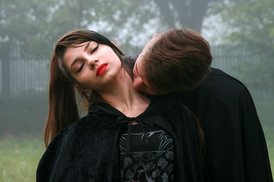 woman wearing black robe while leaning on man wearing black robe during daylight HD wallpaper