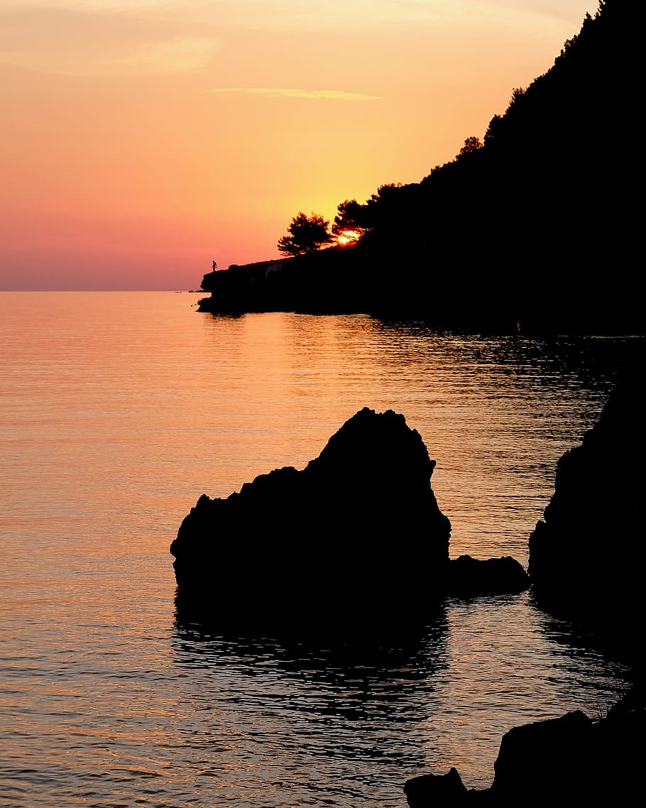brown stone near the island during golden hour photography, silhouette photo of rock on sea during golden hour HD wallpaper