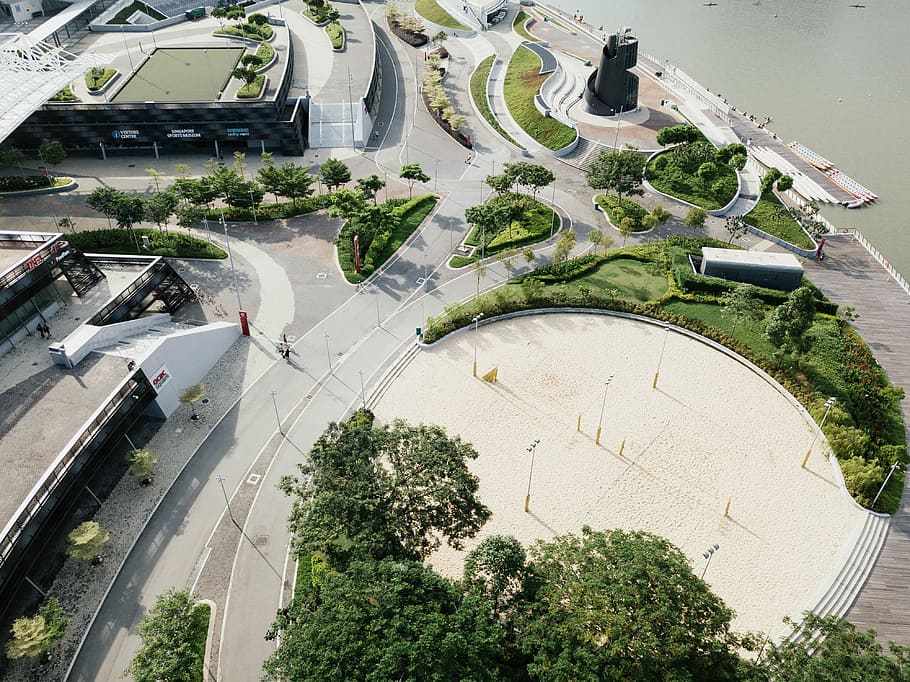aerial photography of park near road beside body of water at daytime \, aerial photography of road near trees at daytime HD wallpaper