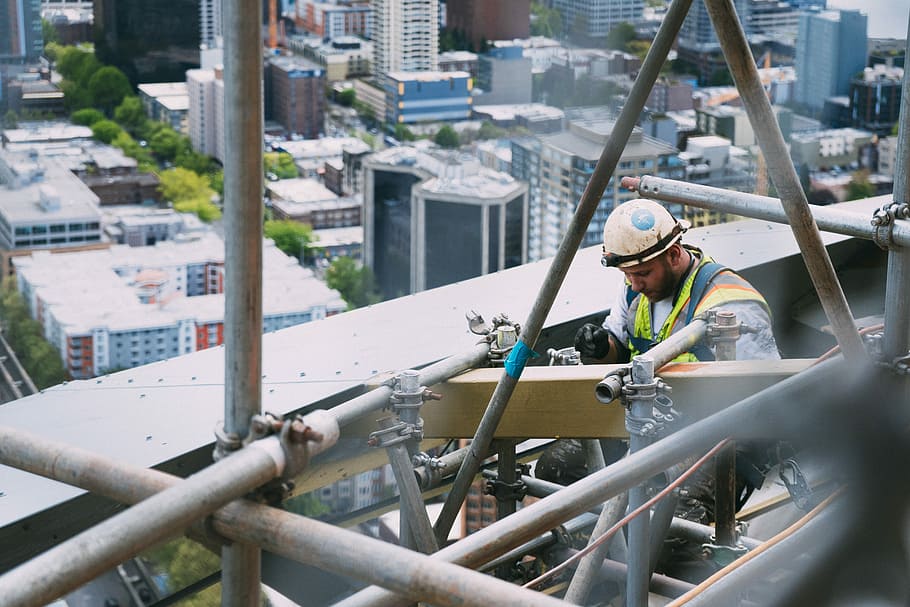 man doing welding on outdoors, man repairing building during daytime HD wallpaper