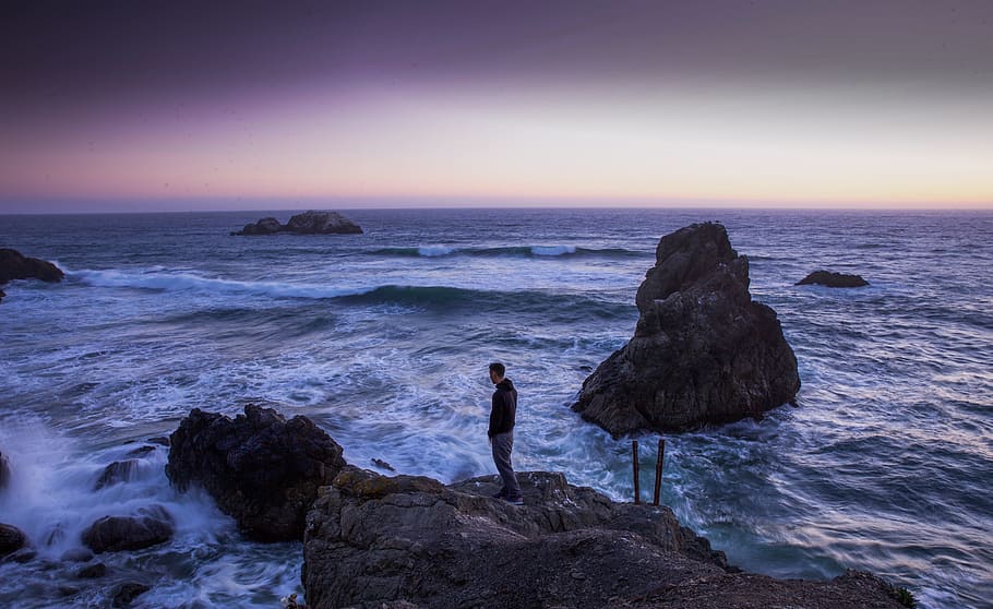 Man in Black Shirt Standing on Rock in Between Sea Water, beach HD wallpaper