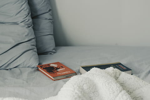 two novel books on bed, two assorted-title books on bed, pillow HD wallpaper