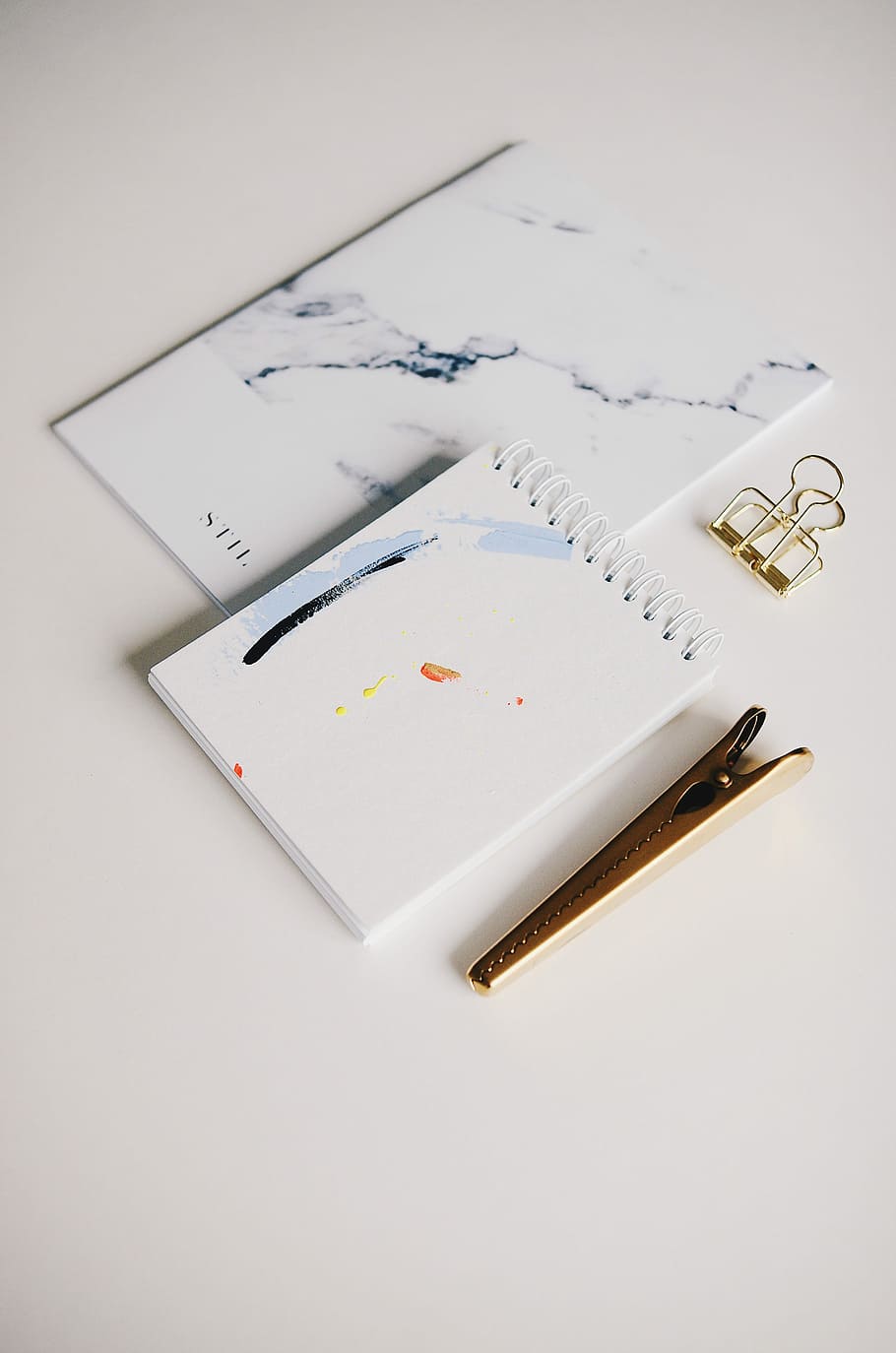 white spiral notebook beside brown clip, white pocket notebook with gray metal clip HD wallpaper
