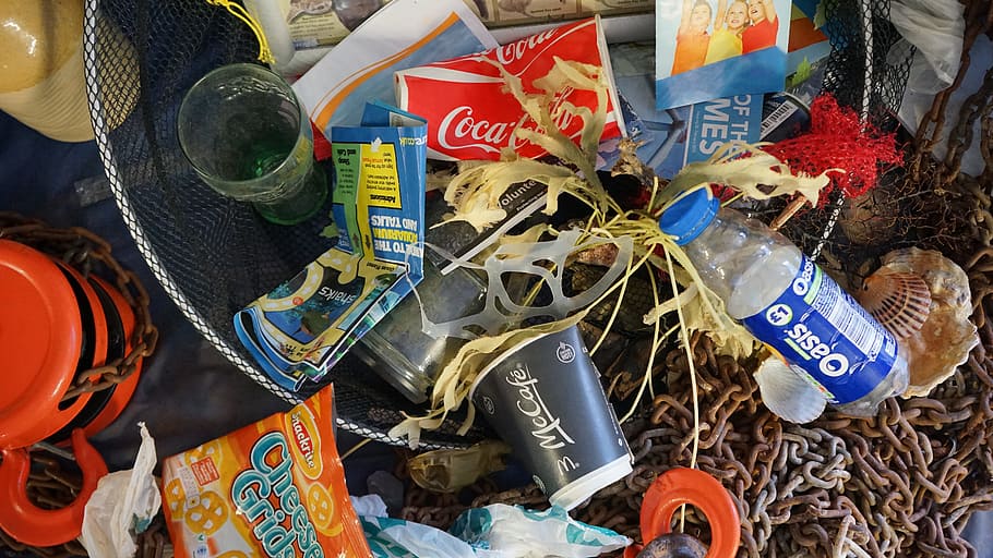 top view photo of assorted labeled bottles, rubbish, seaside