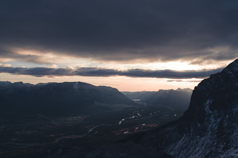 mountains under heavy clouds, road between mountains at night aerial photography HD wallpaper