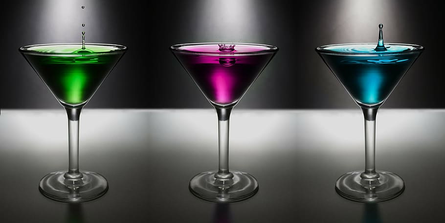 three cocktail glasses filled with assorted-color liquors, martini
