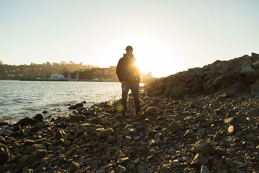 man standing up on rock surface, black, jacket, near, body HD wallpaper