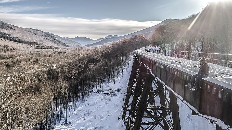 person sitting on brown metal case facing trees photography, person sitting on black metal bridge during daytime HD wallpaper