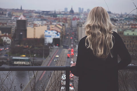 woman standing in front of black metal rail facing road and buildings HD wallpaper
