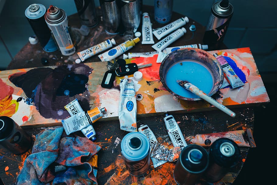 brown paint brush on gray plastic bowl, paint tubes and spray can on table HD wallpaper