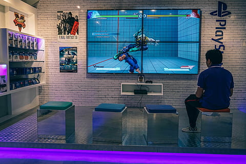 man sitting on chair while playing playstation game, person HD wallpaper