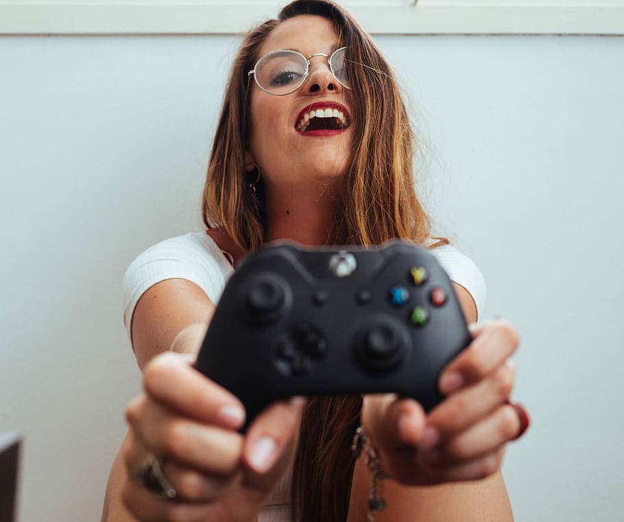 Woman holding a xbox controller and playing popular video game Fortnite on  a television and PC Stock Photo - Alamy