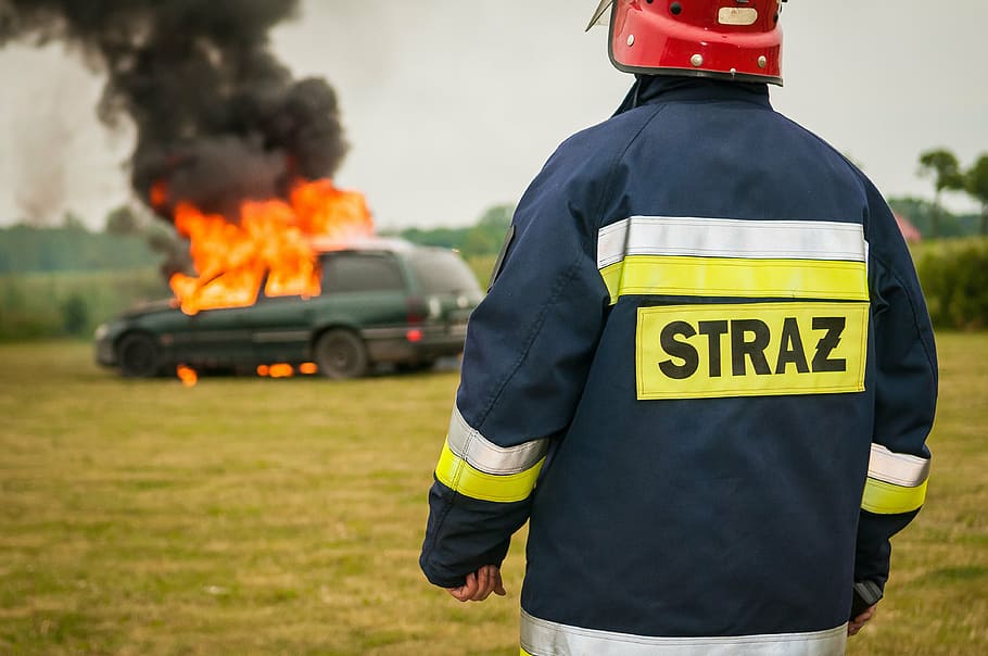 fireman standing near burning green Jeep Grand Cherokee during daytime HD wallpaper