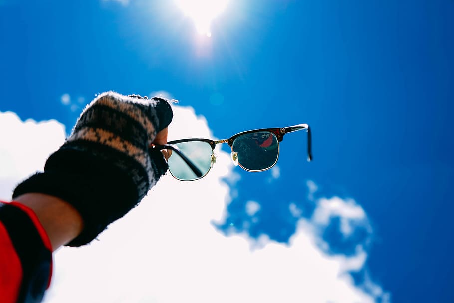 person holding black framed Clubmaster-style sunglasses, person holding sunglasses against the sunlight HD wallpaper