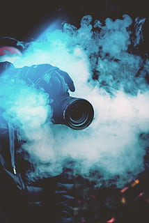 person holding DSLR camera with fogs, black DSLR camera above smoke HD wallpaper