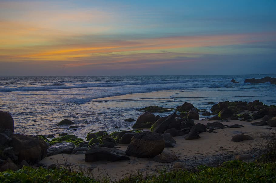 stones near shore during daytime, gray boulders beside body of water HD wallpaper
