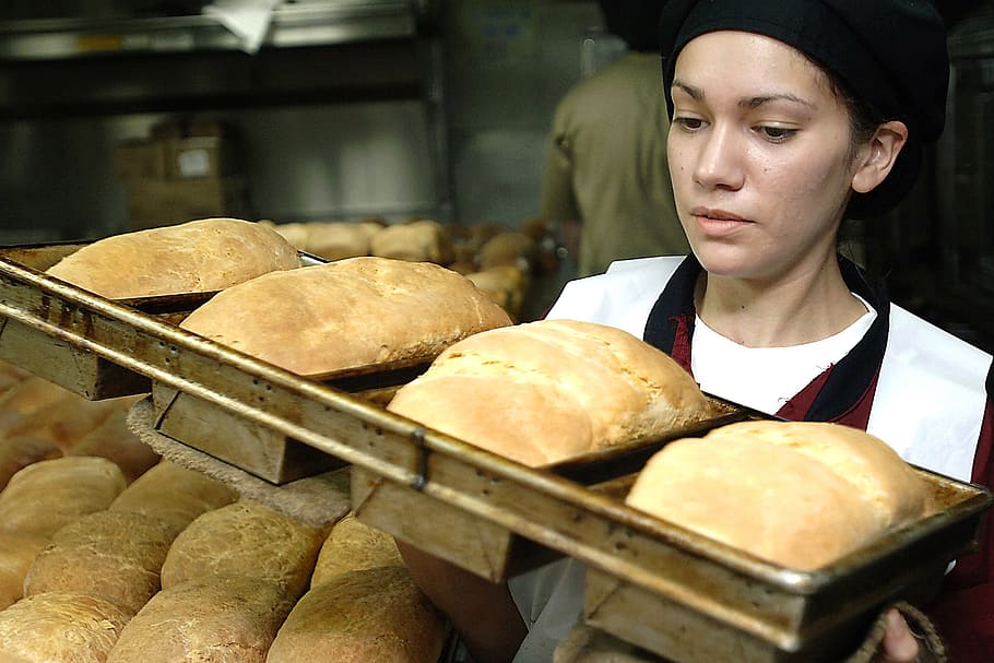 woman carrying a tray of baked breads, baker, baking, cook, food