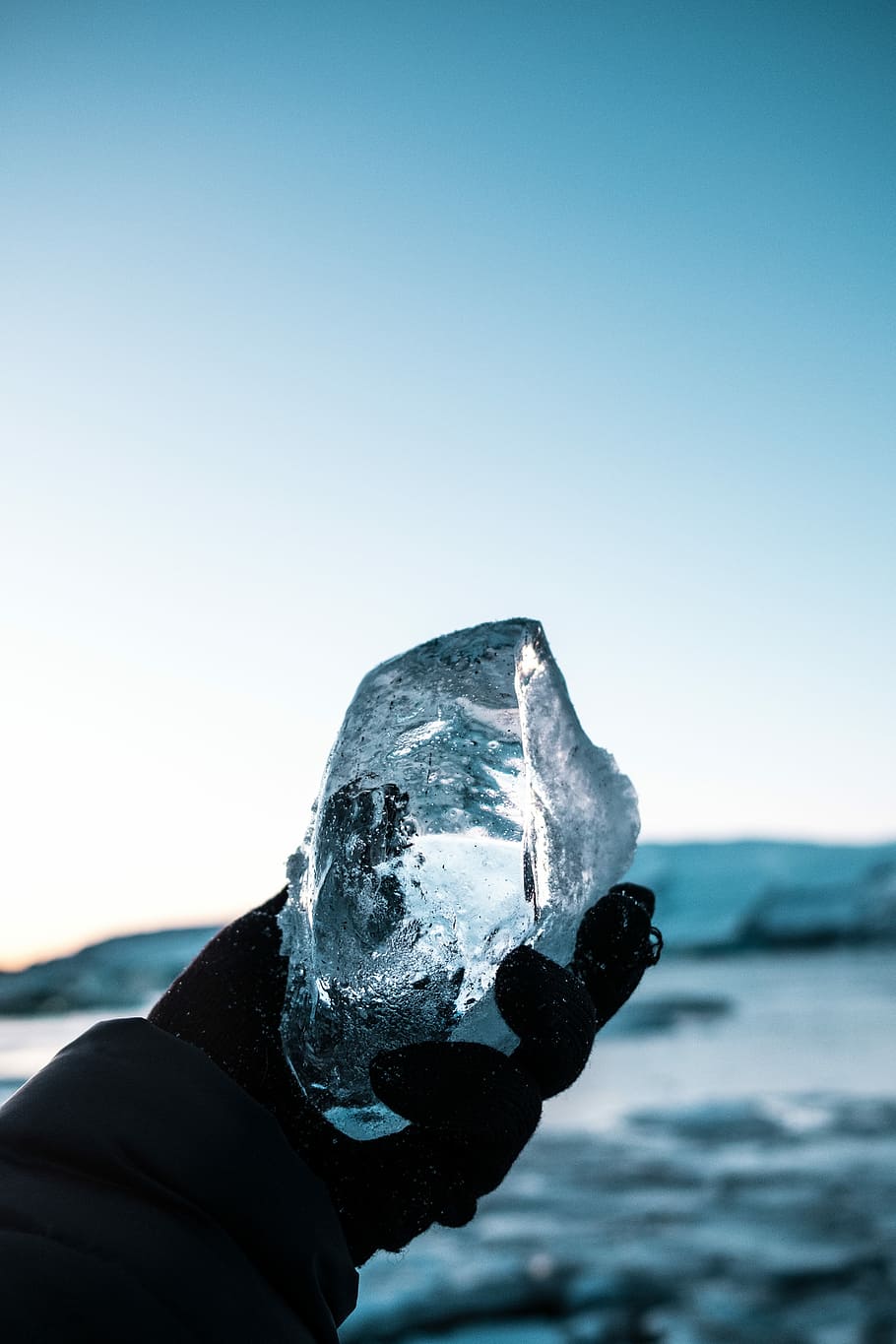 person holding block of ice, person holding ice block under blue sky during daytime HD wallpaper