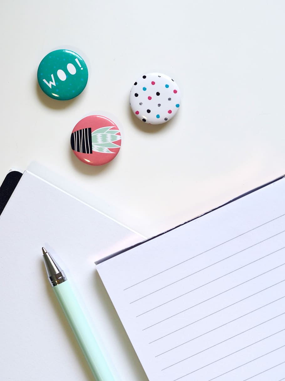 pen and writing paper on white surface with multicolored pebbles HD wallpaper