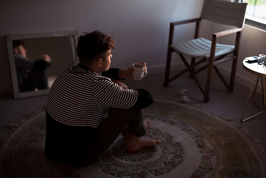 man sitting on rug in front of window, man drinking coffee indoor HD wallpaper