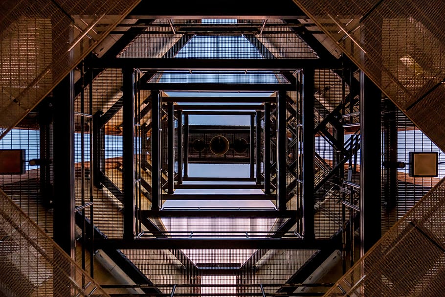low angle photography of black and brown metal scaffolding frames during daytime HD wallpaper