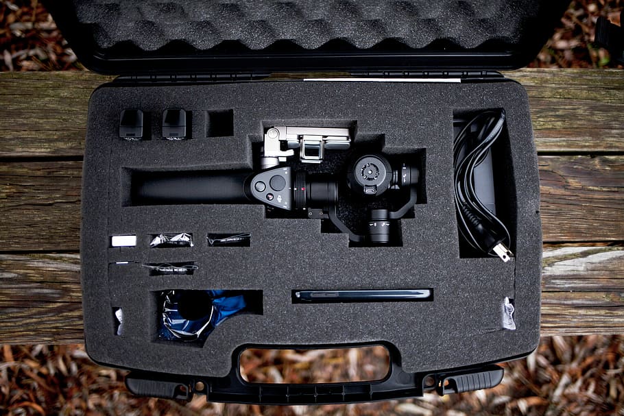 flat-lay photo of camera stabilizer, black SLR camera set on case