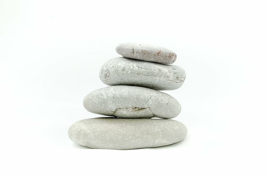 four gray stack pebble, the stones, on a white background, zen
