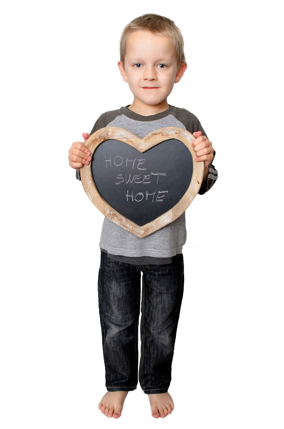 boy hodling heart shaped wooden chalk board with Home Sweet Home written letter