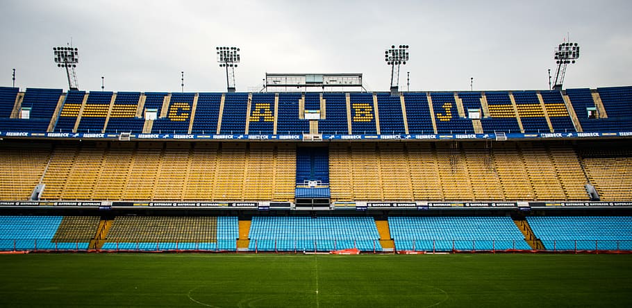 panoramic photography of blue, yellow and teal football stadium during daytime
